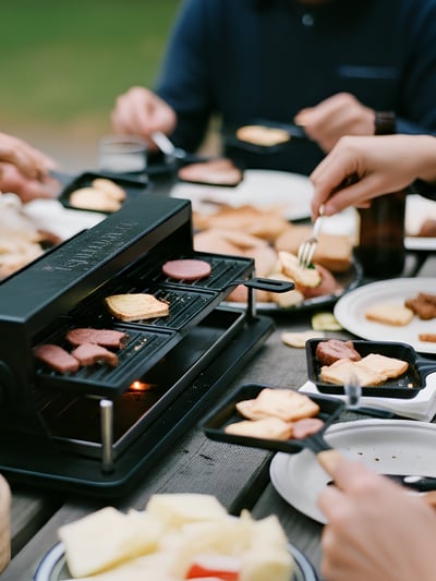 a group of people eating at a campground picnic table using a raclette as an example of RV kitchen appliances